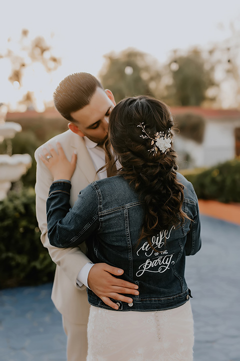  romantic neutral wedding with Spanish flare – couple kissing and the bride in a jean jacket 