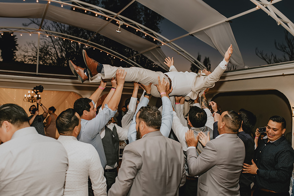  romantic neutral wedding with Spanish flare – groom being lifted