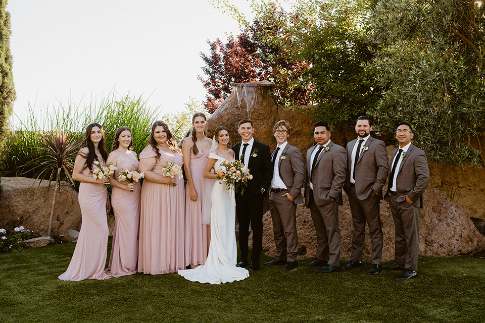  blush and beige wedding with a chic modern twist – the bride in a cap sleeved fitted gown and the groom in a black suit – bridal party