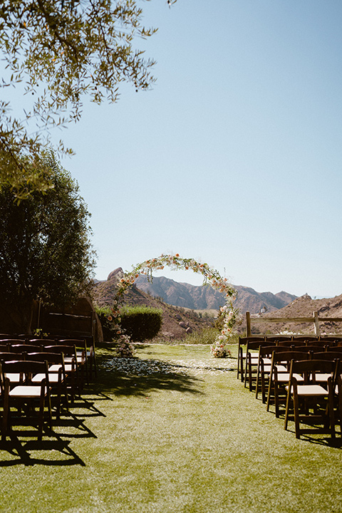  blush and beige wedding with a chic modern twist – the bride in a cap sleeved fitted gown and the groom in a black suit – altar