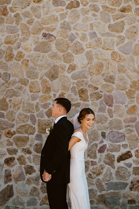  blush and beige wedding with a chic modern twist – the bride in a cap sleeved fitted gown and the groom in a black suit – couple first touch