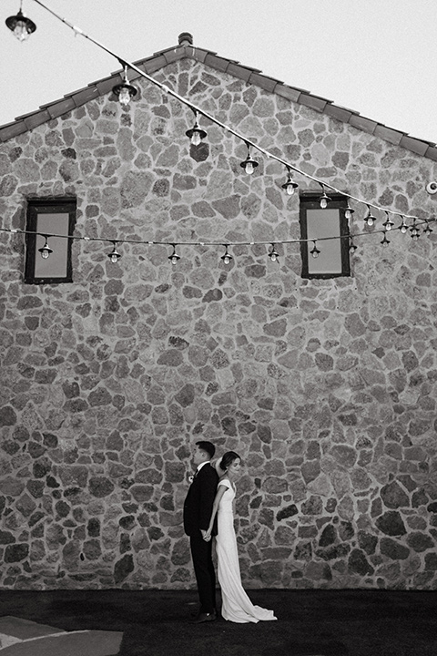  blush and beige wedding with a chic modern twist – the bride in a cap sleeved fitted gown and the groom in a black suit – couple first touch 