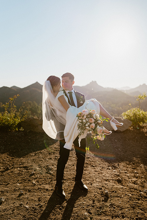  blush and beige wedding with a chic modern twist – the bride in a cap sleeved fitted gown and the groom in a black suit – couple spinning