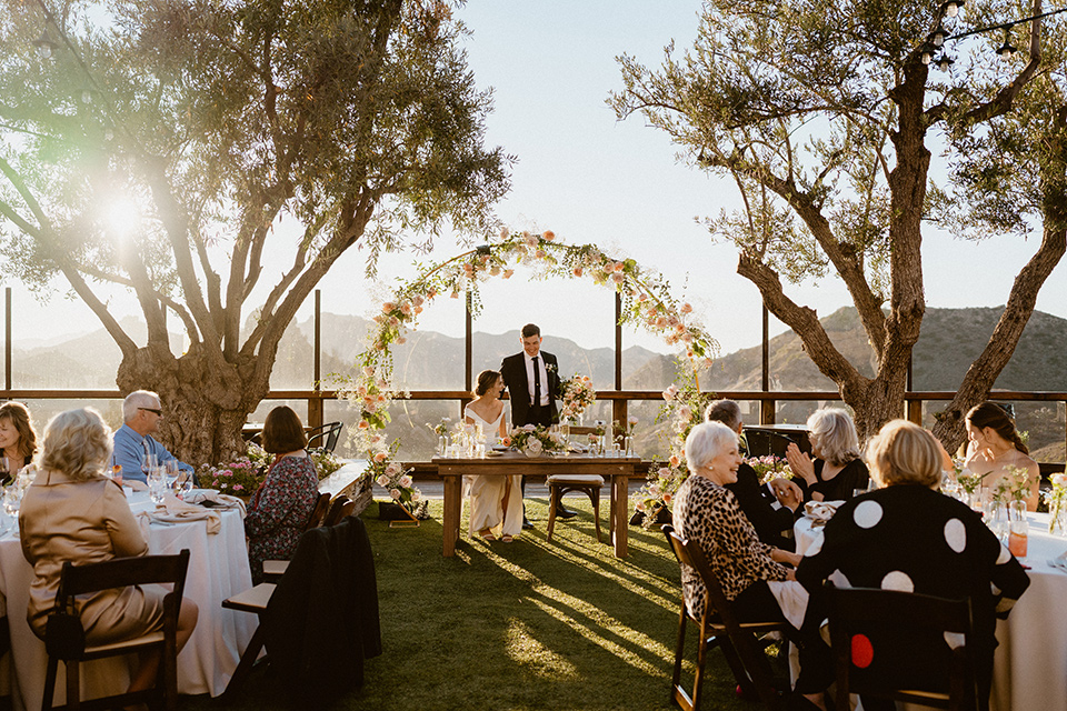  blush and beige wedding with a chic modern twist – the bride in a cap sleeved fitted gown and the groom in a black suit – reception