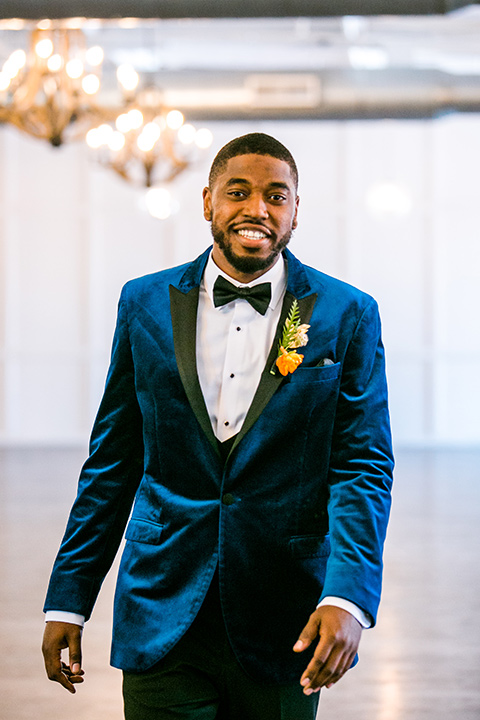  jewel toned wedding with the bride in a ballgown and the groom in a blue velvet tuxedo – walking down the aisle