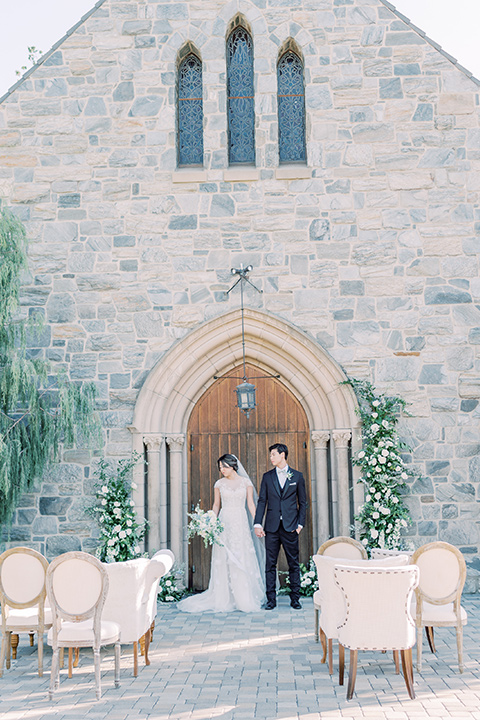  old world wedding style with the bride is a Bridgerton-style gown and the groom in an asphalt suit - ceremony 