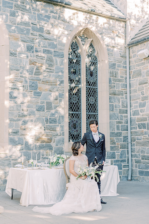  old world wedding style with the bride is a Bridgerton-style gown and the groom in an asphalt suit - reception tables and sweetheart table 