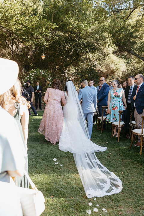 a classic blush and blue wedding design in a garden venue - bride walking down the aisle 