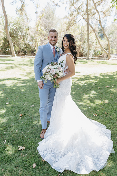  a classic blush and blue wedding design in a garden venue - couple walking 