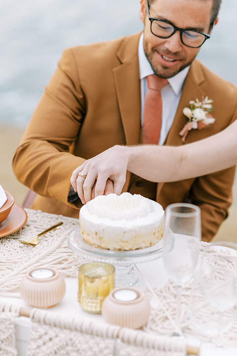  sunset cliffs elopement with confetti poppers and a chic picnic – groom cutting the cake