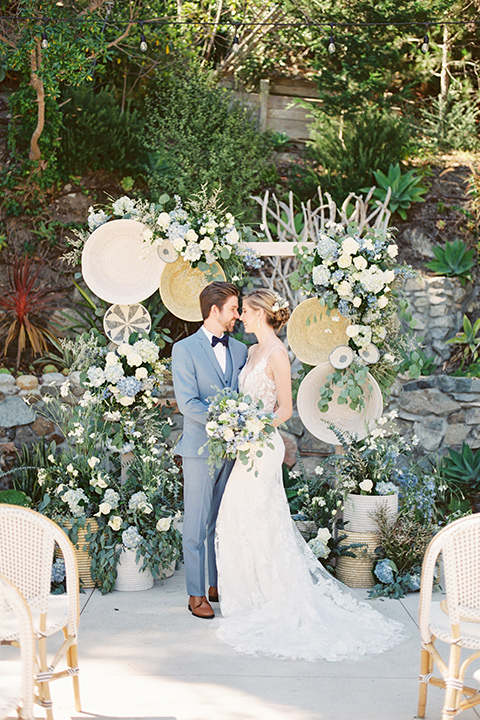  blue beachy wedding with blue and pink décor and the groom in a light blue suit – couple at ceremony 