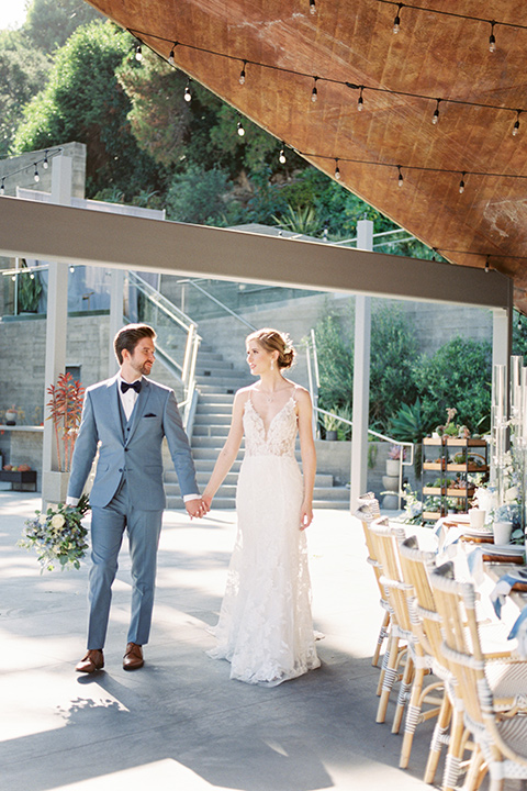  blue beachy wedding with blue and pink décor and the groom in a light blue suit – couple at tables 