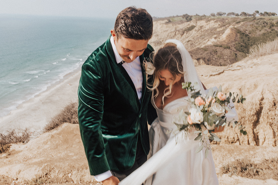  elopement on the cliffs with the bride in a ball gown with poof sleeves and the groom in a green velvet tuxedo 