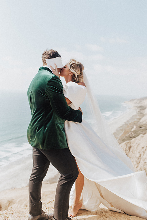  elopement on the cliffs with the bride in a ball gown with poof sleeves and the groom in a green velvet tuxedo 