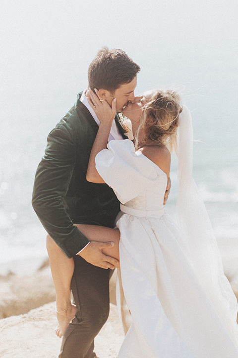  elopement on the cliffs with the bride in a ball gown with poof sleeves and the groom in a green velvet tuxedo 