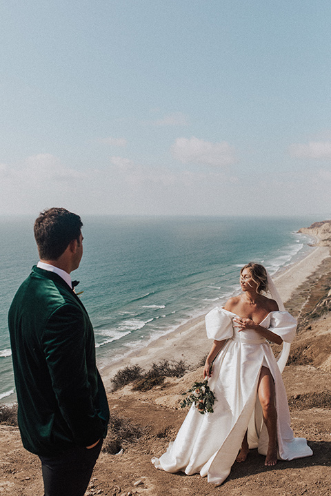  elopement on the cliffs with the bride in a ball gown with poof sleeves and the groom in a green velvet tuxedo 