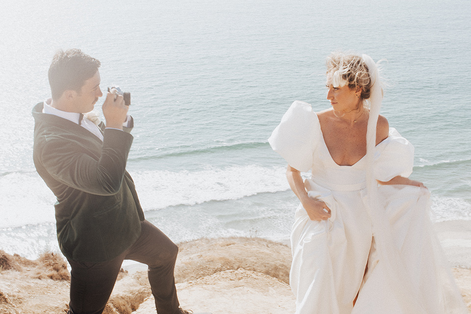  elopement on the cliffs with the bride in a ball gown with poof sleeves and the groom in a green velvet tuxedo 