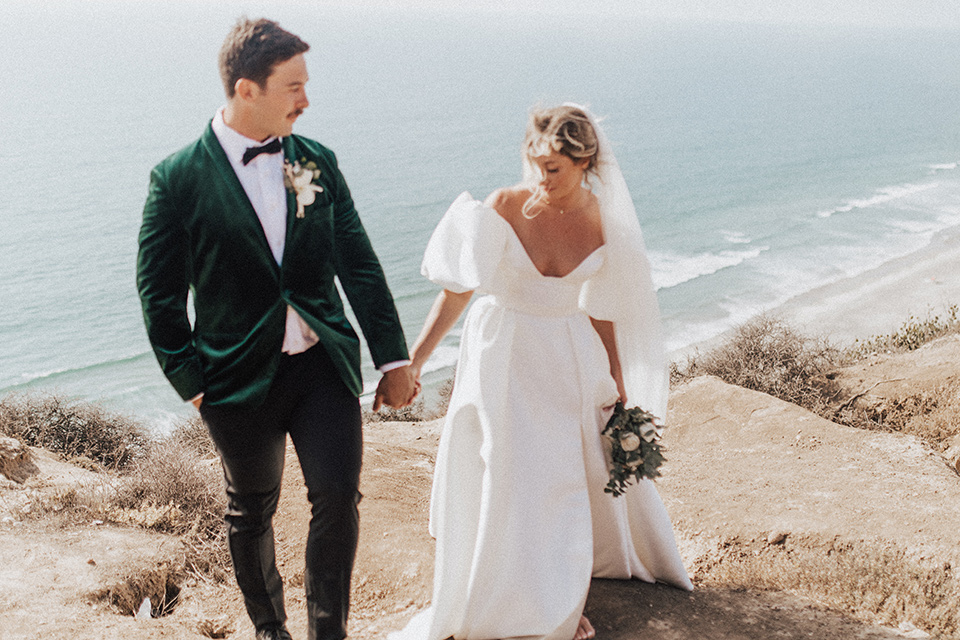  elopement on the cliffs with the bride in a ball gown with poof sleeves and the groom in a green velvet tuxedo 