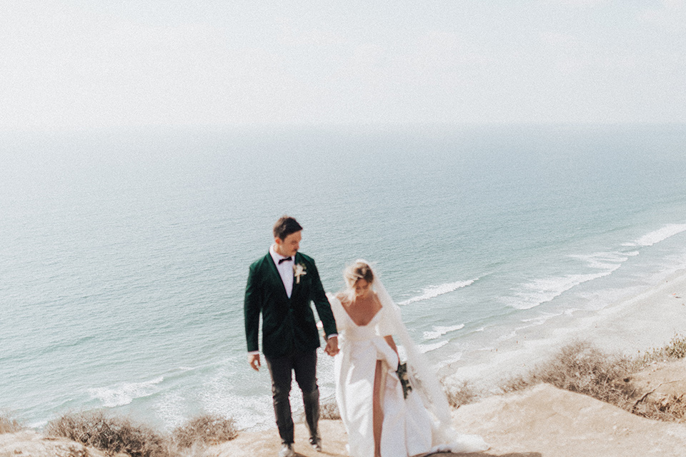  elopement on the cliffs with the bride in a ball gown with poof sleeves and the groom in a green velvet tuxedo 