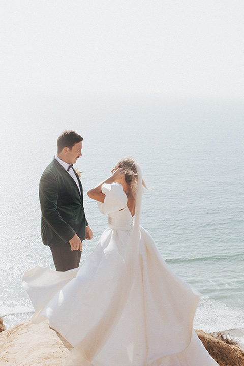  elopement on the cliffs with the bride in a ball gown with poof sleeves and the groom in a green velvet tuxedo 