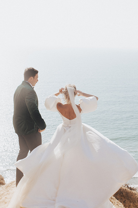  elopement on the cliffs with the bride in a ball gown with poof sleeves and the groom in a green velvet tuxedo 