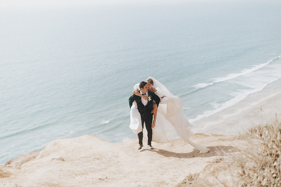  elopement on the cliffs with the bride in a ball gown with poof sleeves and the groom in a green velvet tuxedo 