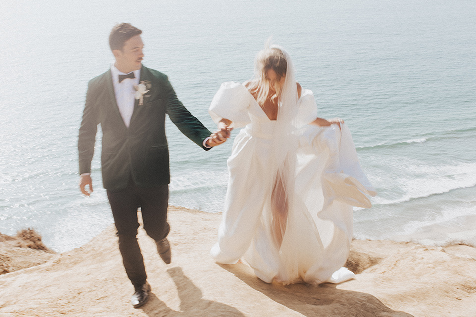  elopement on the cliffs with the bride in a ball gown with poof sleeves and the groom in a green velvet tuxedo 