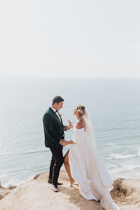  elopement on the cliffs with the bride in a ball gown with poof sleeves and the groom in a green velvet tuxedo 