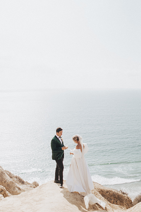  elopement on the cliffs with the bride in a ball gown with poof sleeves and the groom in a green velvet tuxedo 