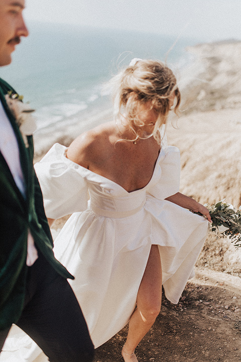  elopement on the cliffs with the bride in a ball gown with poof sleeves and the groom in a green velvet tuxedo 