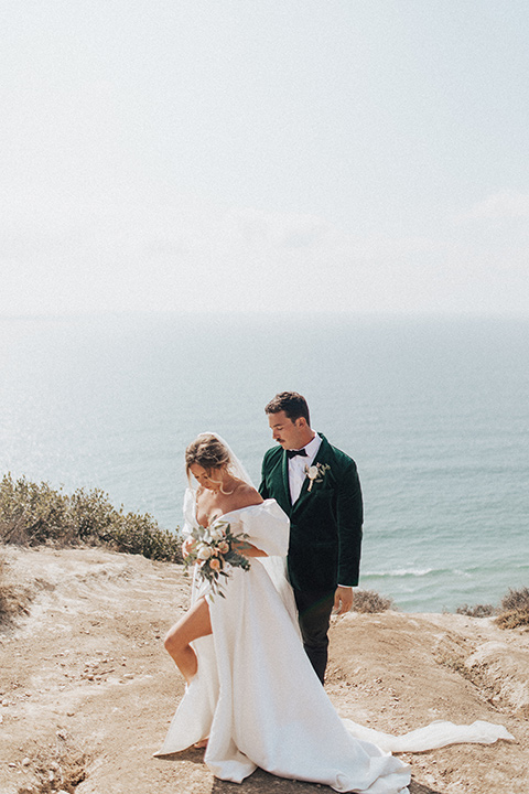  elopement on the cliffs with the bride in a ball gown with poof sleeves and the groom in a green velvet tuxedo 