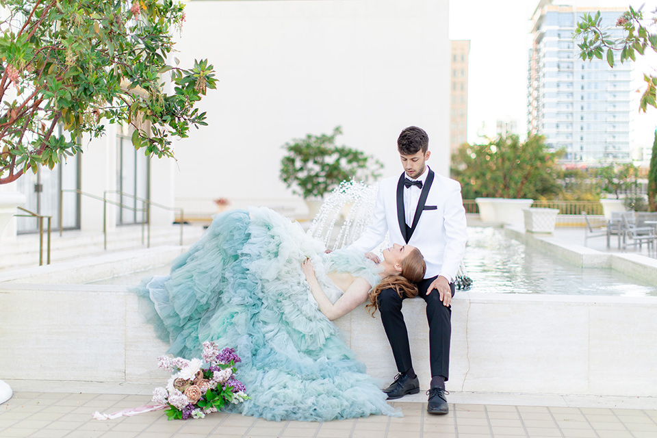  fun wedding at the Westgate hotel and the bride in a blue tulle gown and the groom in a white and black tuxedo – couple by the fountain