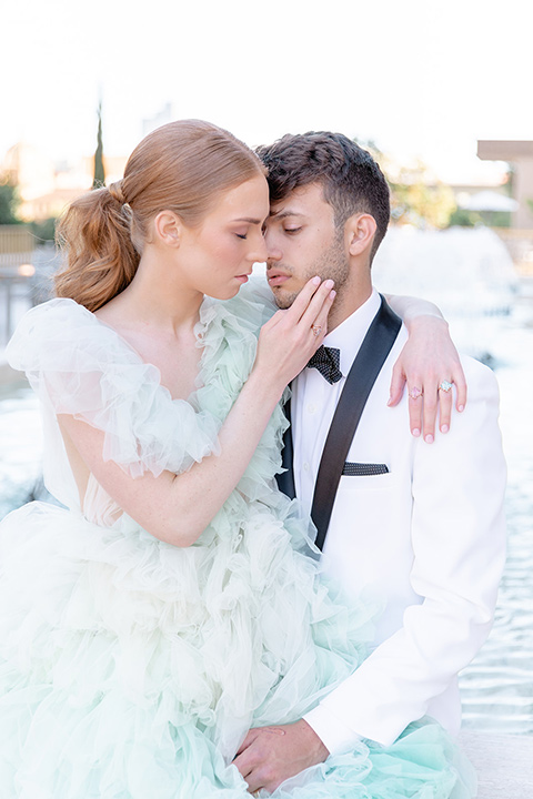  fun wedding at the Westgate hotel and the bride in a blue tulle gown and the groom in a white and black tuxedo - couple embracing 