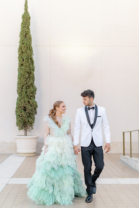  fun wedding at the Westgate hotel and the bride in a blue tulle gown and the groom in a white and black tuxedo - couple outside walking 