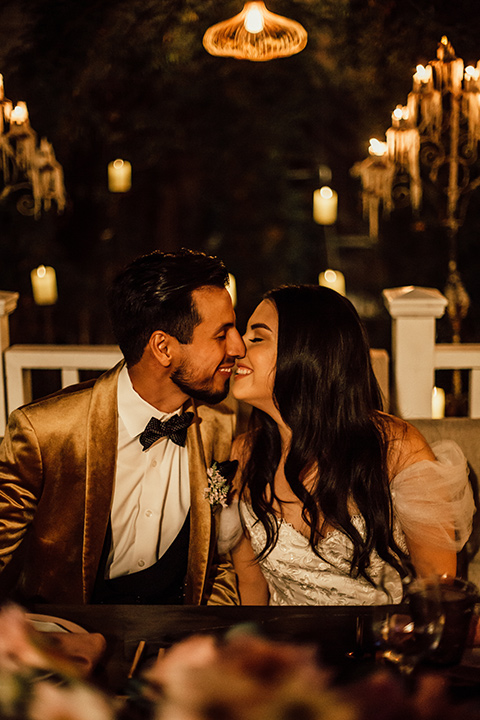  whimsical fairytale wedding with the groom in a gold velvet tuxedo – couple kissing 