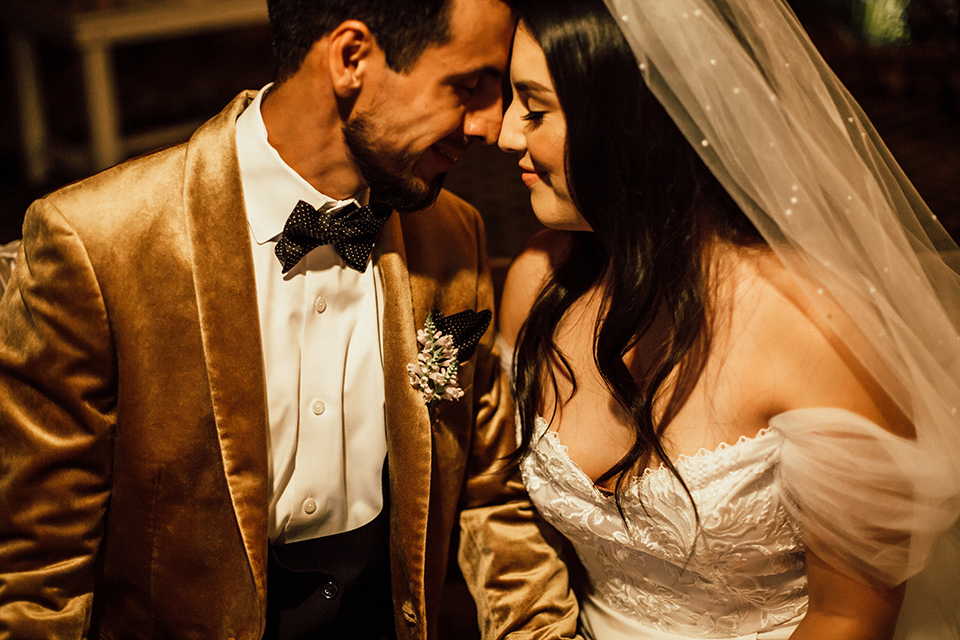  whimsical fairytale wedding with the groom in a gold velvet tuxedo – bride and groom kissing