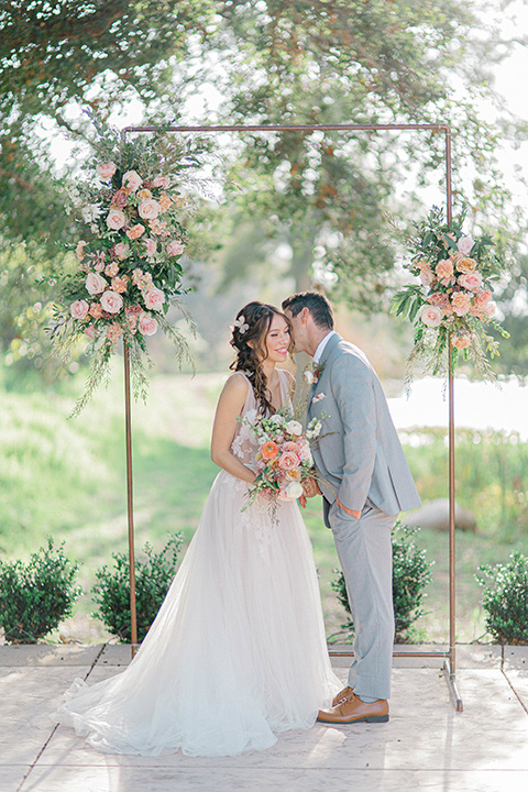  whimsical romance wedding with the bride in a ballgown and the groom in a light grey suit – ceremony