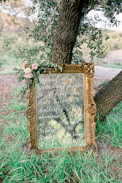  whimsical romance wedding with the bride in a ballgown and the groom in a light grey suit – welcome sign 