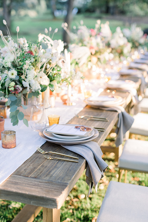  wine country wedding with the bride in a jumpsuit and the groom in a burgundy tux- table florals