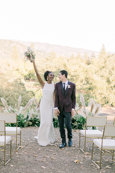  wine country wedding with the bride in a jumpsuit and the groom in a burgundy tux- ceremony