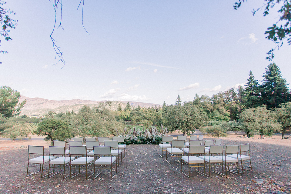  wine country wedding with the bride in a jumpsuit and the groom in a burgundy tux- ceremony space 