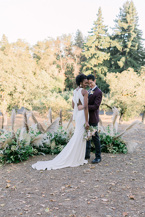  wine country wedding with the bride in a jumpsuit and the groom in a burgundy tux- ceremony