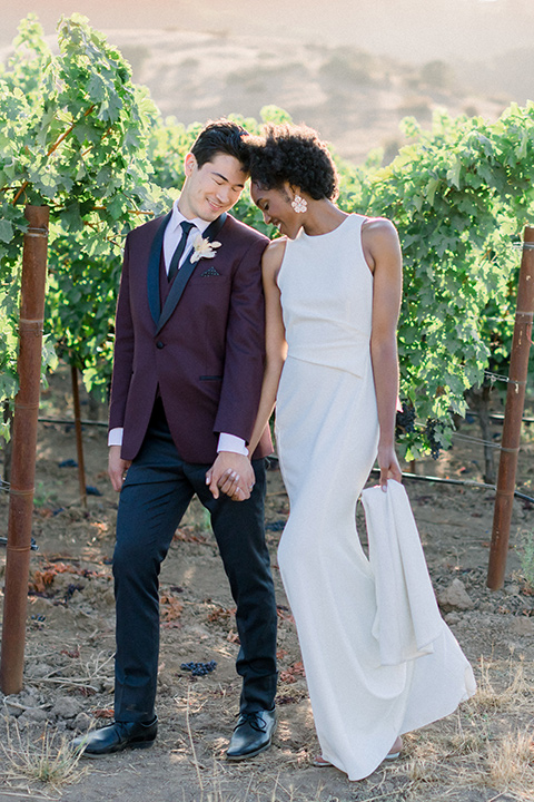  wine country wedding with the bride in a jumpsuit and the groom in a burgundy tux- in the vineyard 