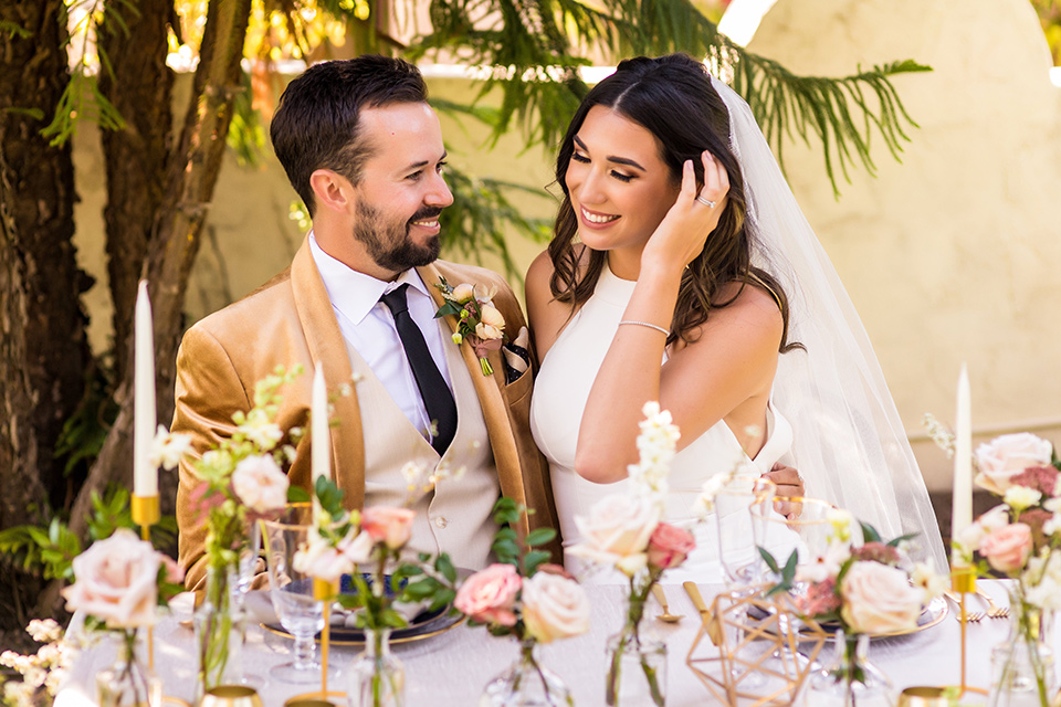  fun pink and champagne wedding with the bride in a pink tulle gown and the groom n a tan and pink look- couple sitting at the table