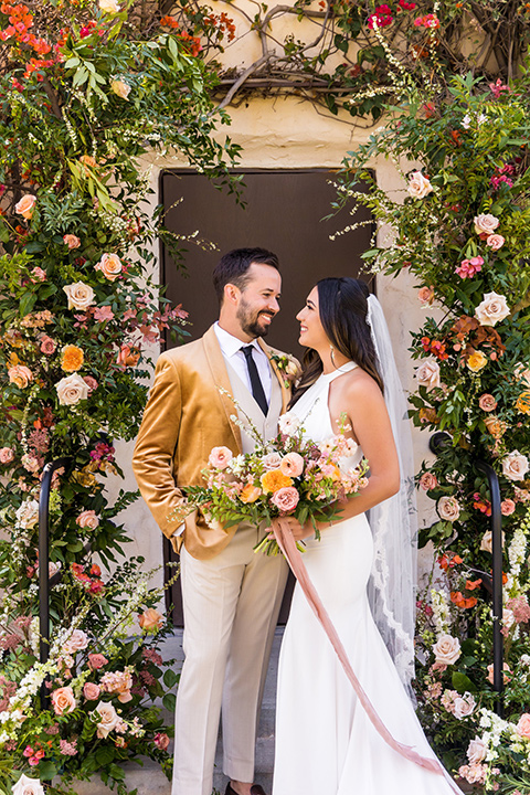  fun pink and champagne wedding with the bride in a pink tulle gown and the groom n a tan and pink look- couple at ceremony 