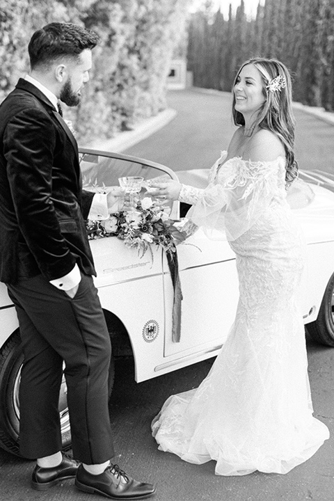  black and white modern wedding at the caramel mountain estate with the bride in a lace gown and the groom in a black velvet tuxedo – by the vintage car 