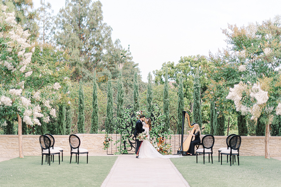  black and white modern wedding at the caramel mountain estate with the bride in a lace gown and the groom in a black velvet tuxedo – couple at ceremony 