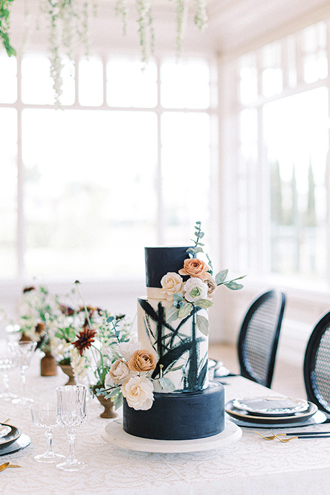  black and white modern wedding at the caramel mountain estate with the bride in a lace gown and the groom in a black velvet tuxedo – black and white wedding reception decor and cake