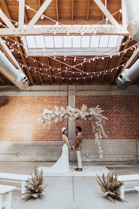  bohemian wedding with neutral colors and the groom in a gold velvet tuxedo – couple at the ceremony 