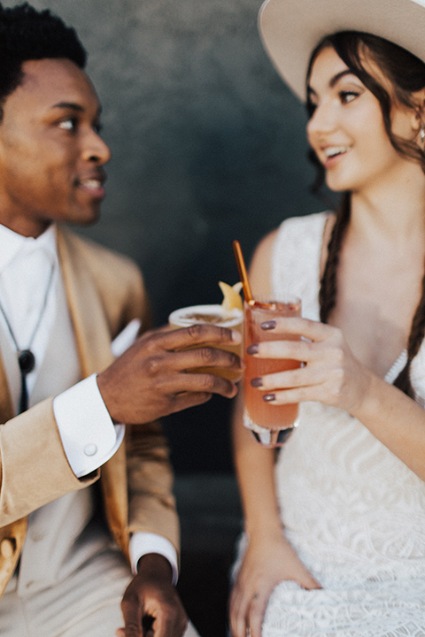  bohemian wedding with neutral colors and the groom in a gold velvet tuxedo – couple cheersing 